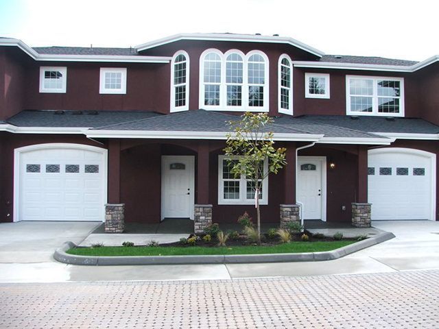 A large brown house with white garage doors
