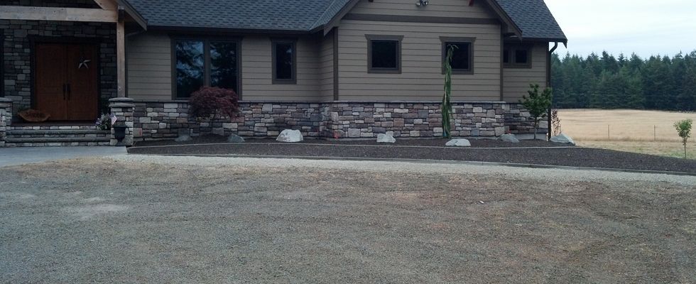 A large house with a gravel driveway in front of it.