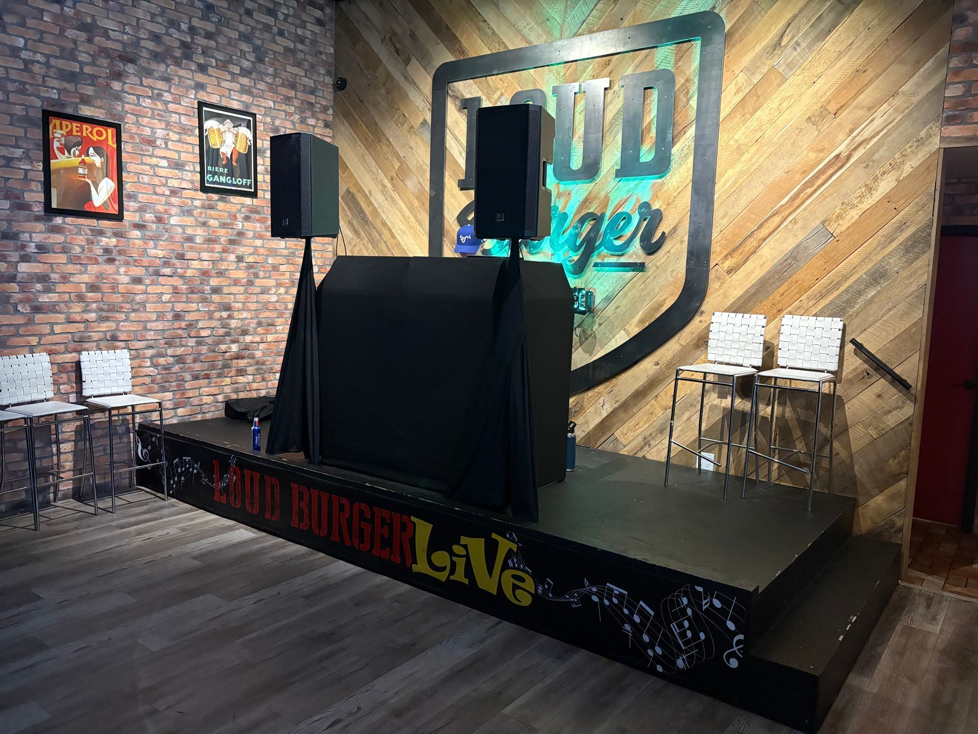 Stage setup with speakers and a DJ booth for live events.