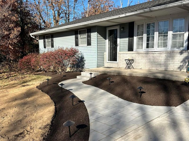 There is a walkway leading to the front of the house.