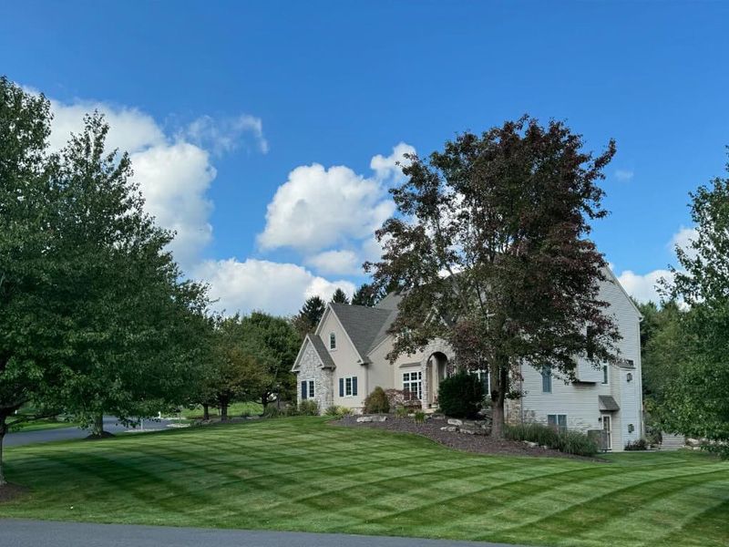 A large white house with a lush green lawn in front of it