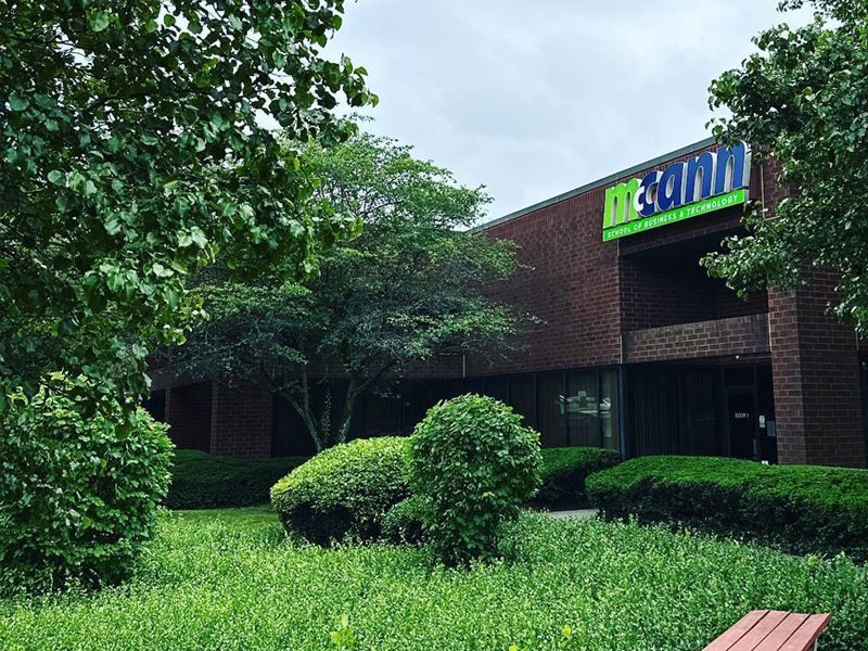 A large brick building with a green and blue sign that says design on it.