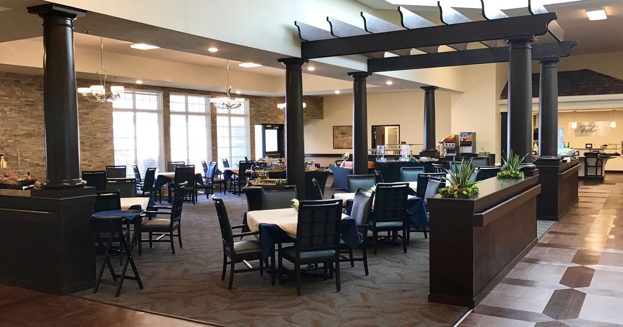A large dining room with tables and chairs and a pergola.