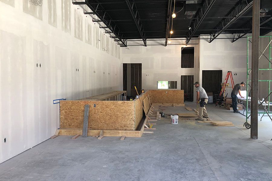 A group of men are working in a large empty room.