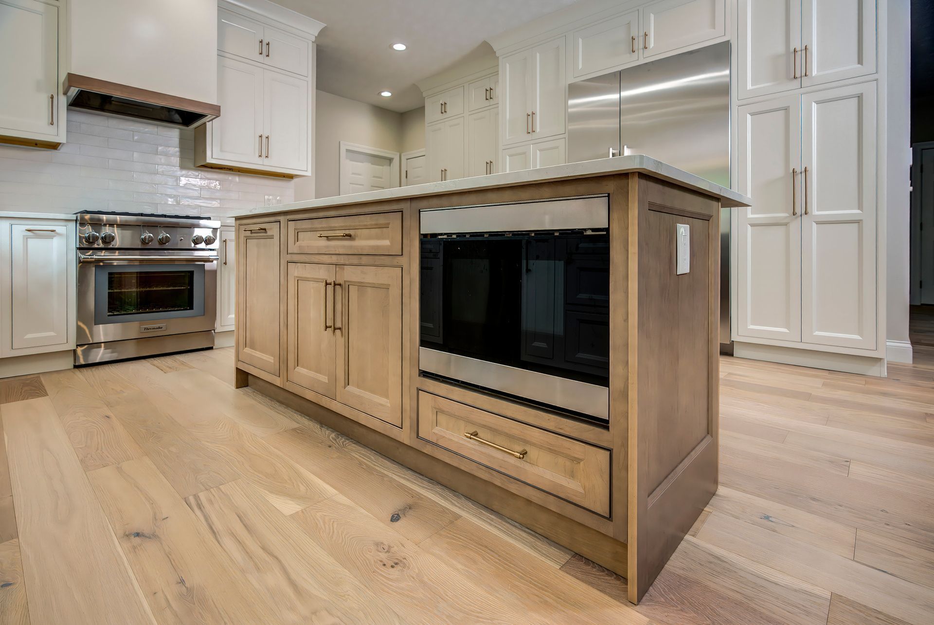 Light wood kitchen island with a built-in microwave, set in a bright kitchen.