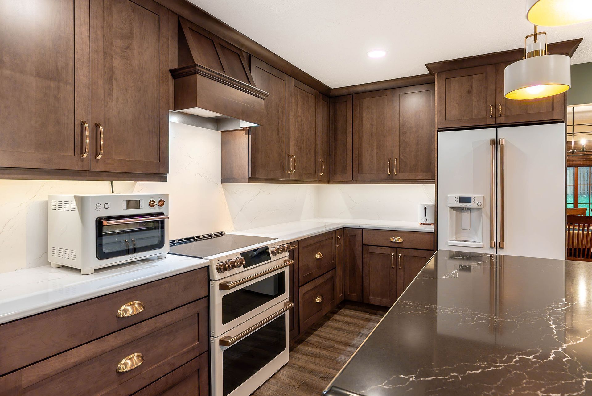 Dark wood kitchen cabinets and appliances with a white countertop and island.