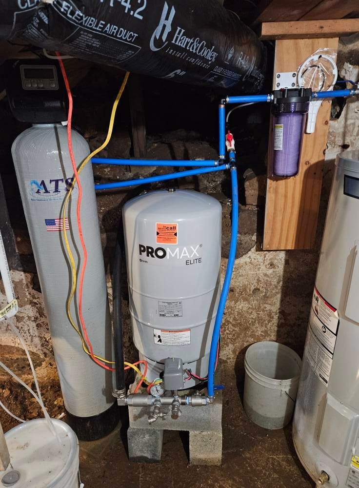 Water filtration and treatment system in a basement. Includes a tank, filter, pressure tank, and pipes.