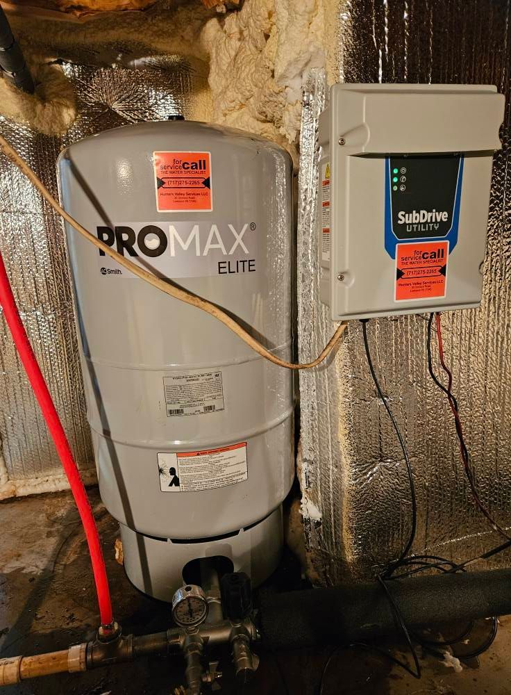Water well pressure tank and control box in a basement.