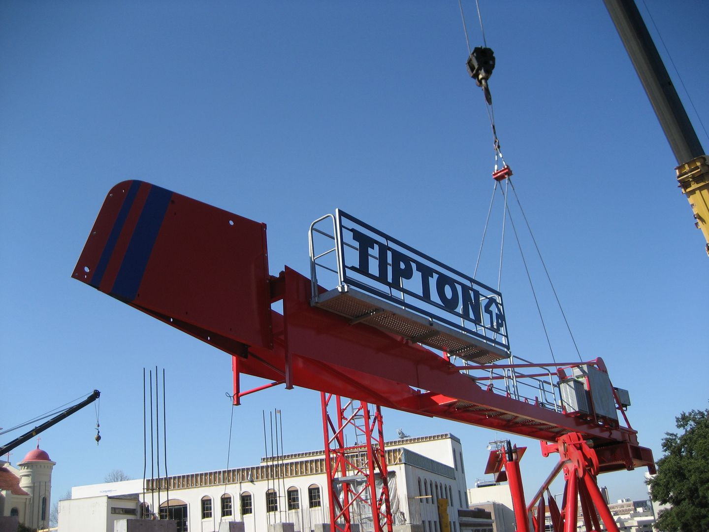 A crane is lifting a sign that says tipton 's