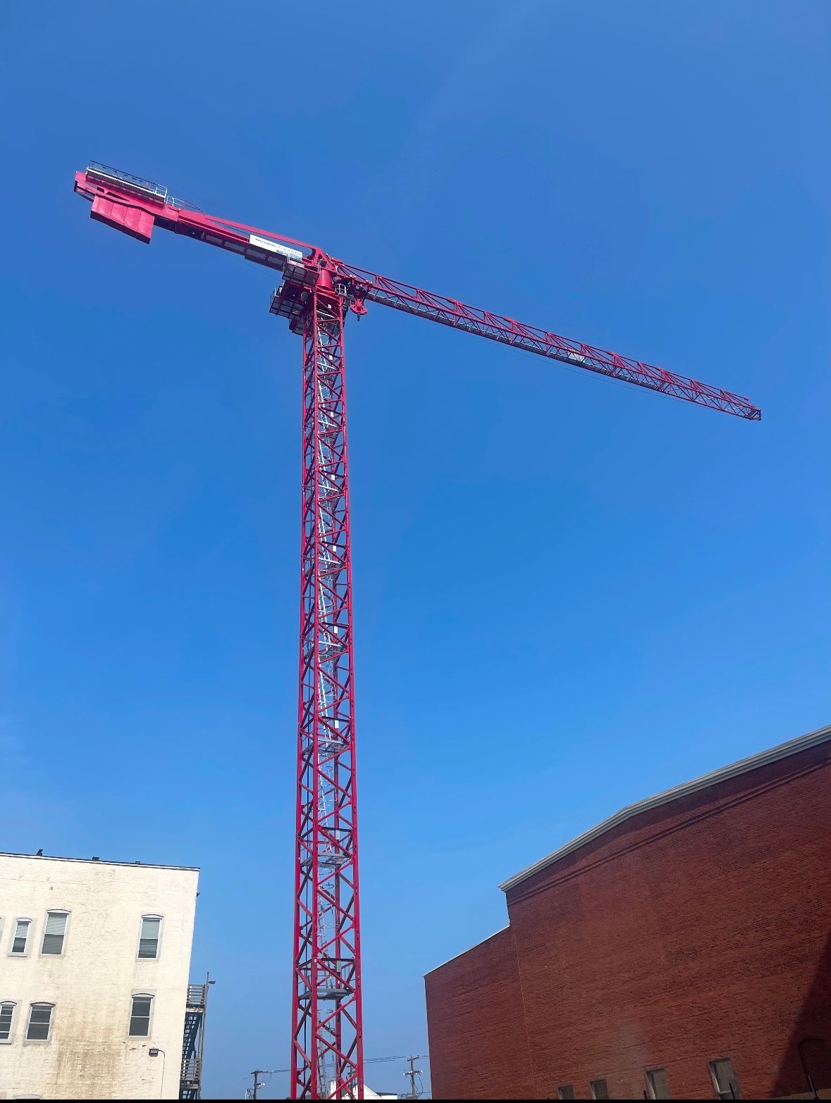 A large red crane is against a blue sky