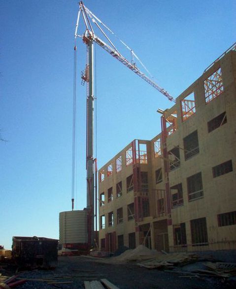 A large building under construction with a crane in front of it