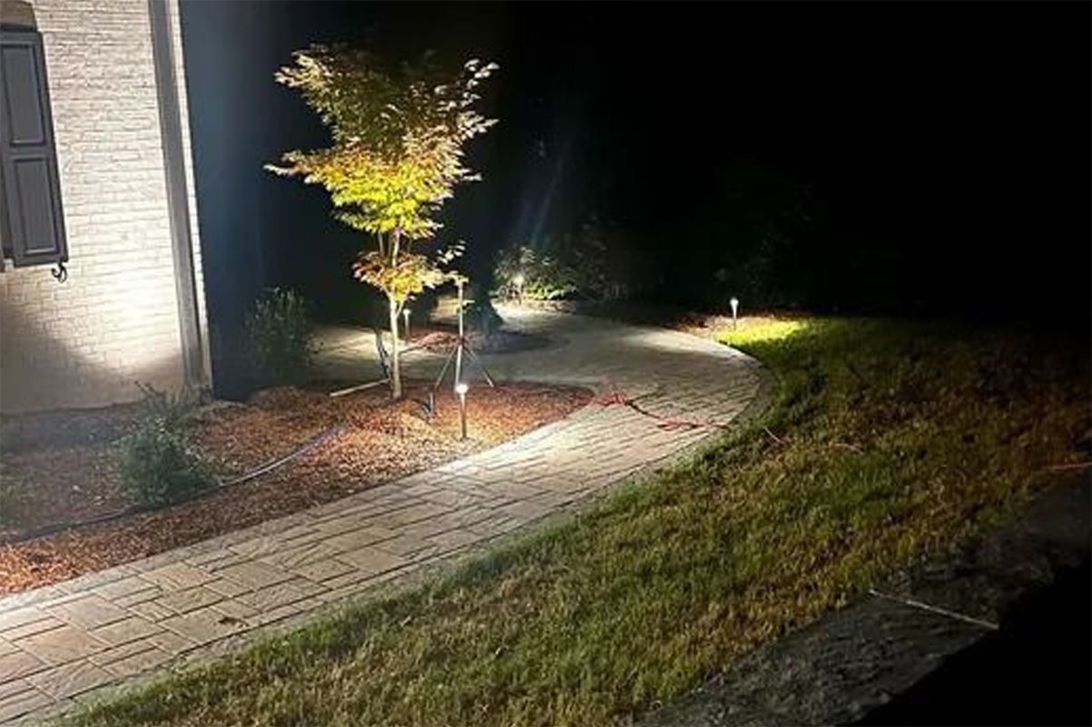 Nighttime sidewalk beside a lit building