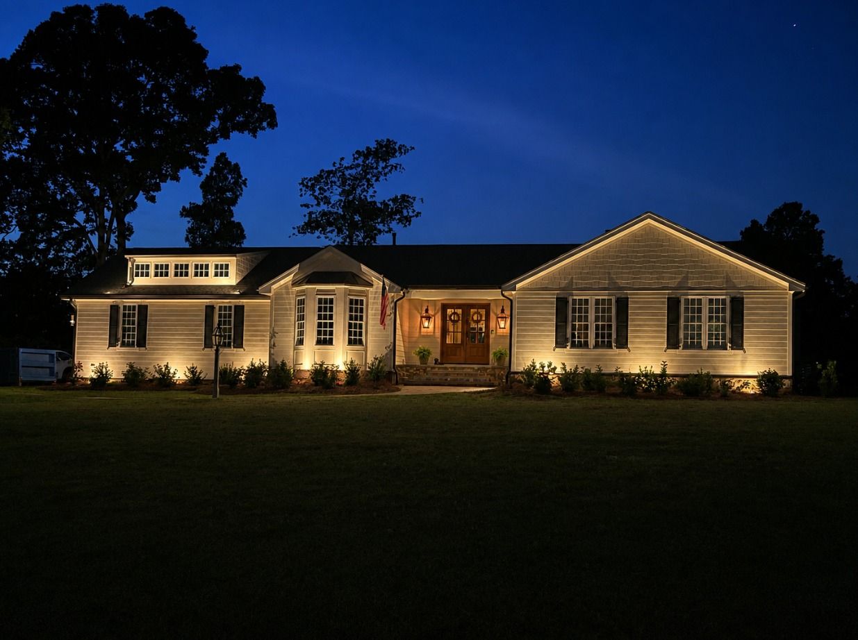 Single-story house warmly lit at night against a dark blue sky