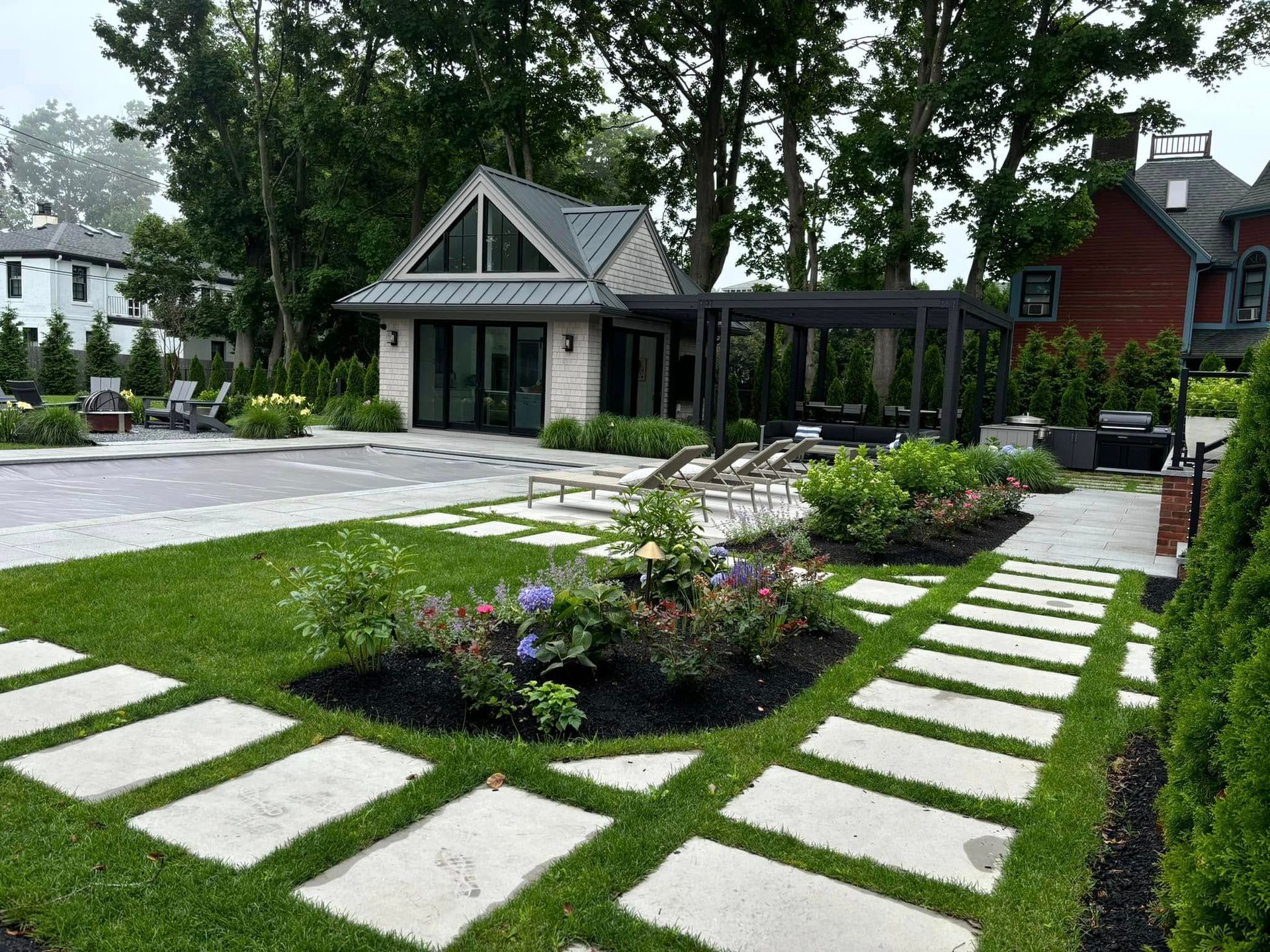 A lush green lawn with a stone walkway leading to a house.