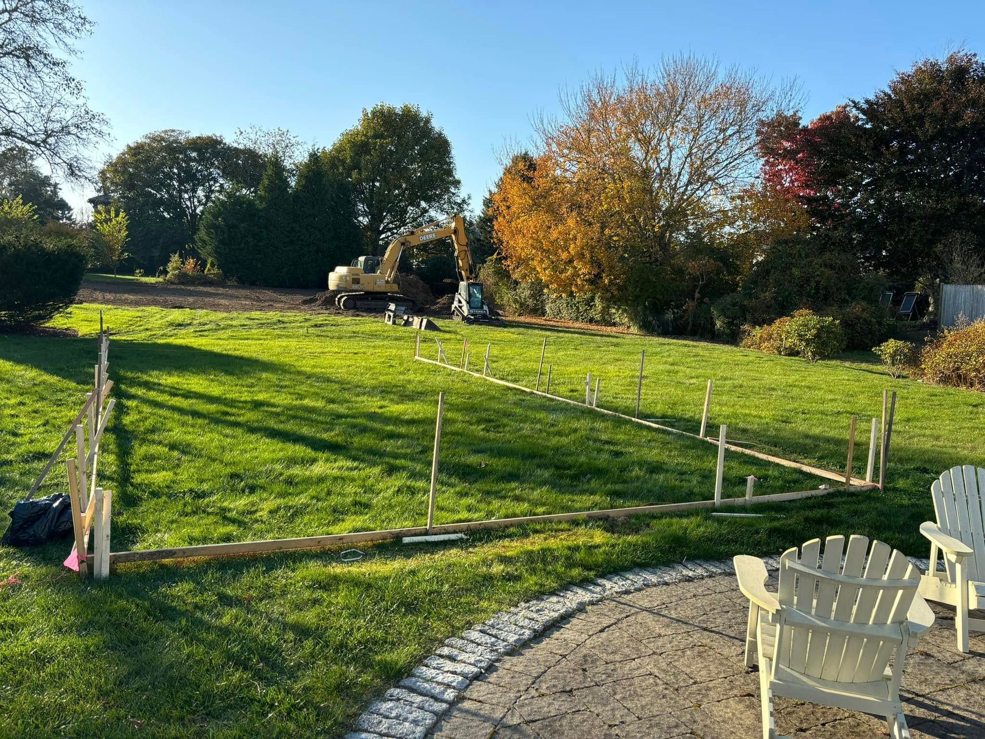 There are two chairs in the middle of a grassy field.