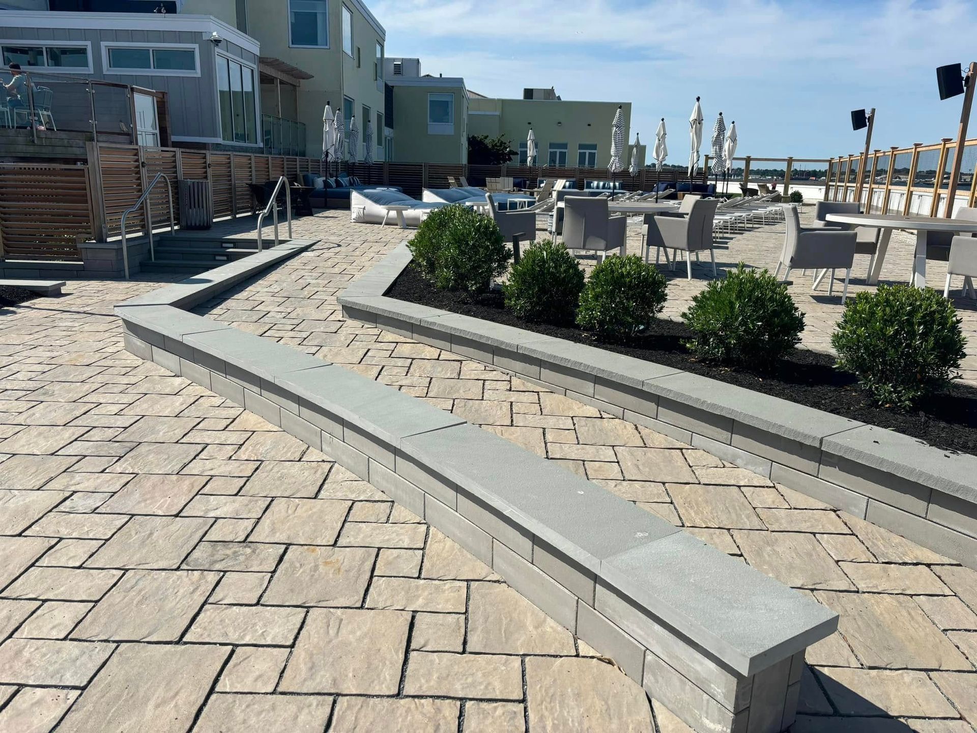 A brick walkway with a bench in the middle of it