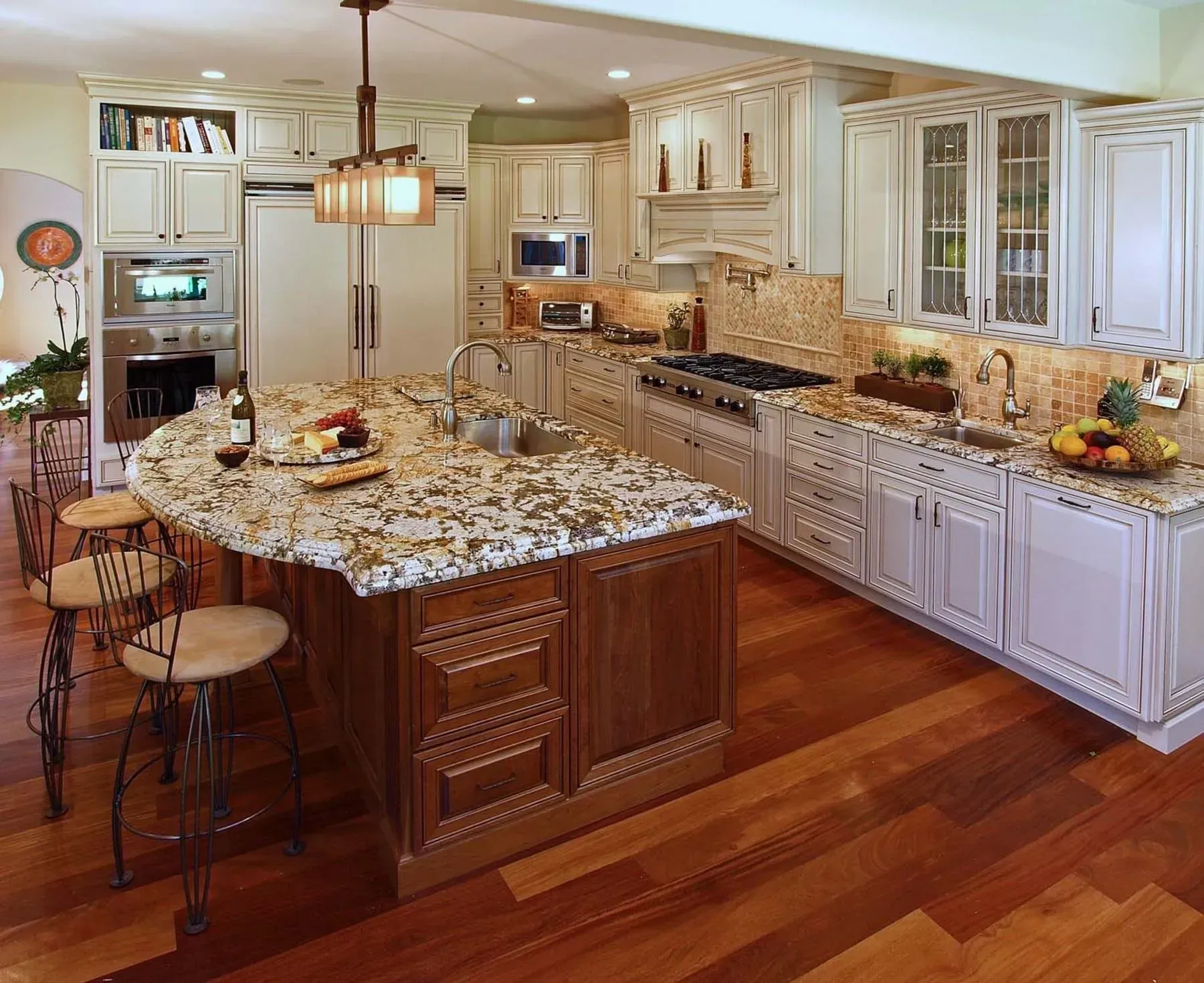 Elegant kitchen with white cabinets, wood island, granite countertops, and hardwood floors.