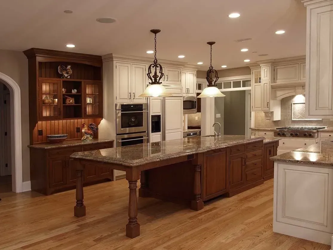 Spacious kitchen with wood cabinets, central island, and granite countertops. Two pendant lights hang over the island.