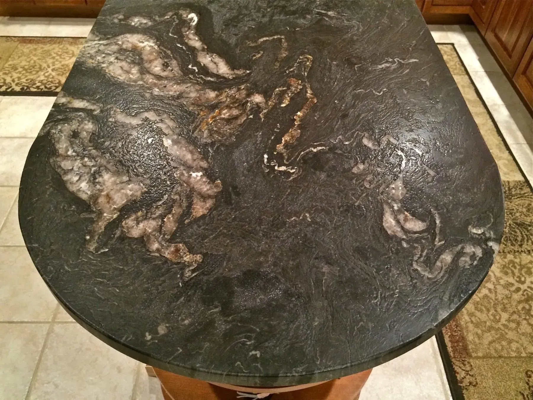 Dark granite countertop with swirling patterns, in a kitchen setting.