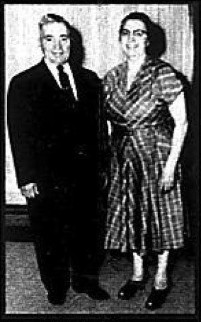 A man and a woman are standing next to each other in a black and white photo.