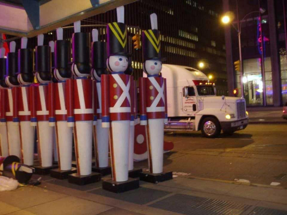 A truck is driving past a row of toy soldiers