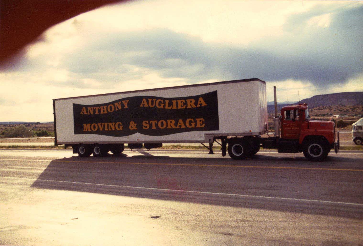 An anthony augliera moving and storage truck is parked on the side of the road