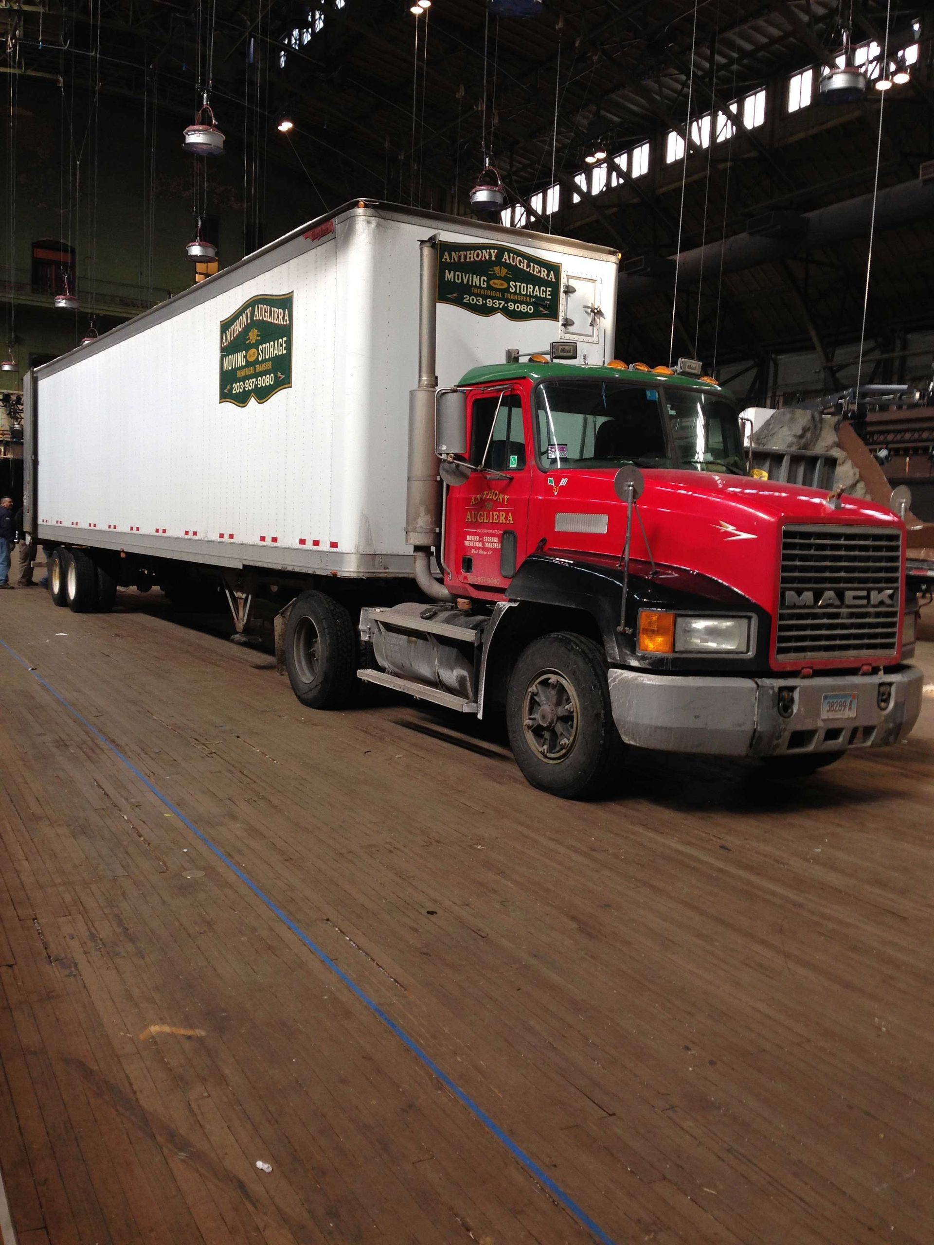 A red mack truck is parked in a warehouse