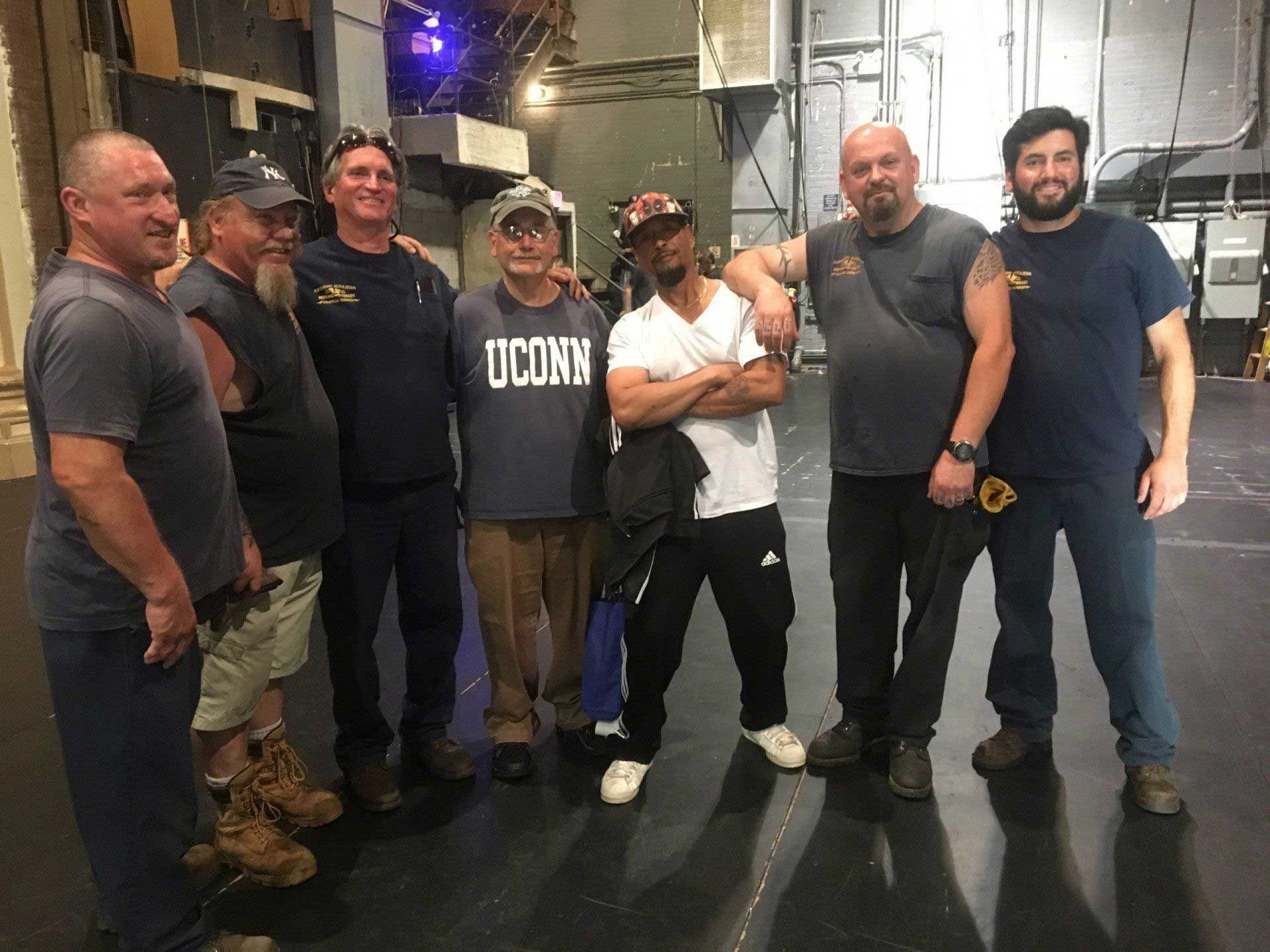 A group of men are posing for a picture in a room.