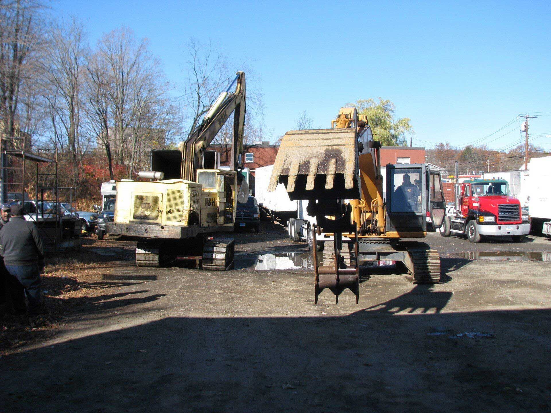 A group of construction vehicles are parked in a parking lot