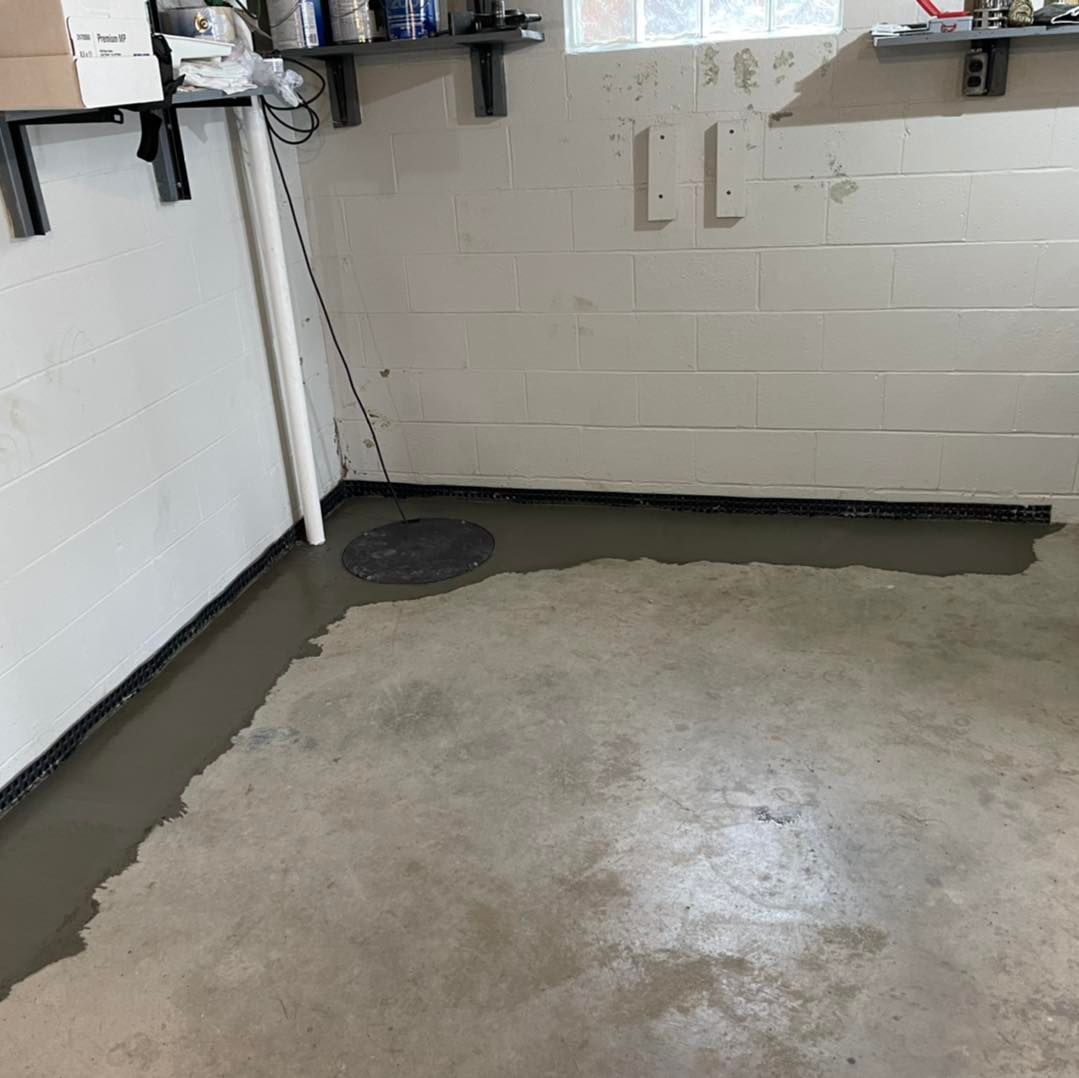 A room with a concrete floor and a brick wall.