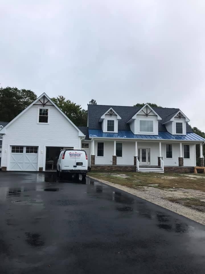 a white house with a blue roof and a white van parked in front of it .