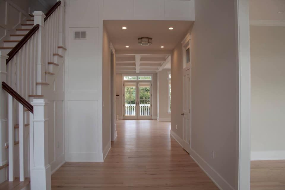 a kitchen with white cabinets , granite counter tops , and hardwood floors .