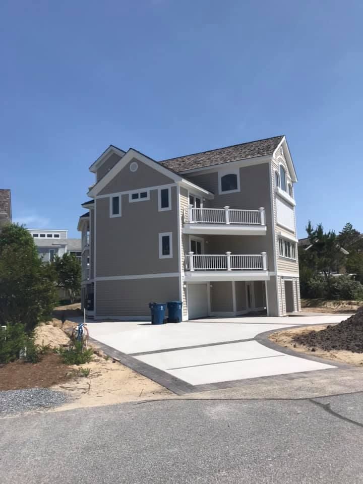 an empty living room with a ceiling fan and lots of windows .