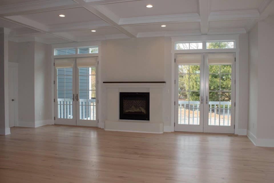an empty living room with hardwood floors and a fireplace .