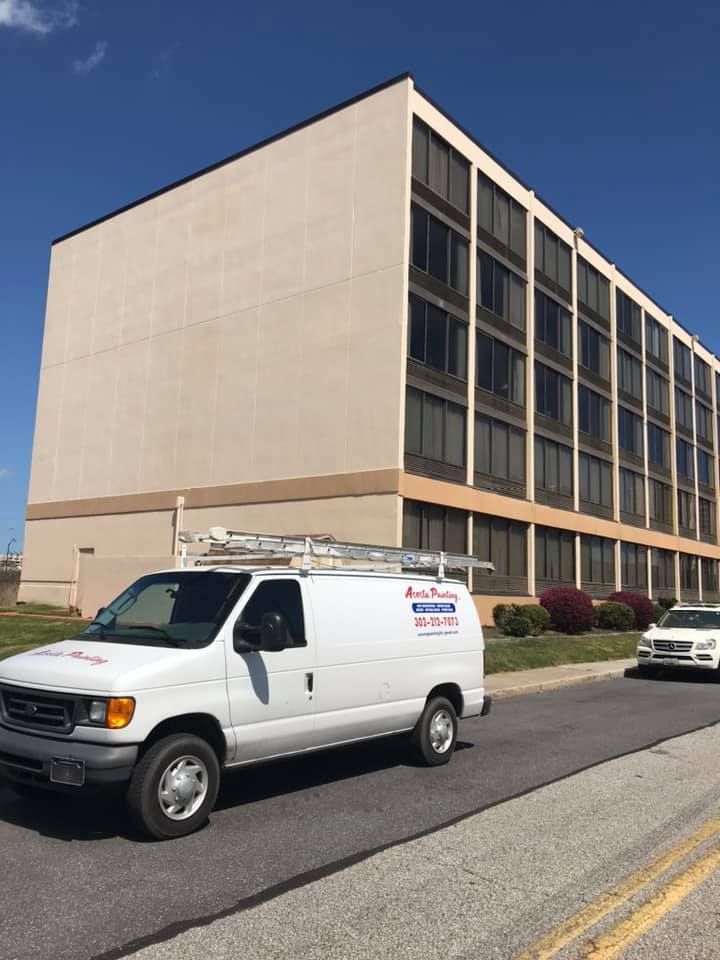 a white van is parked in front of a large building