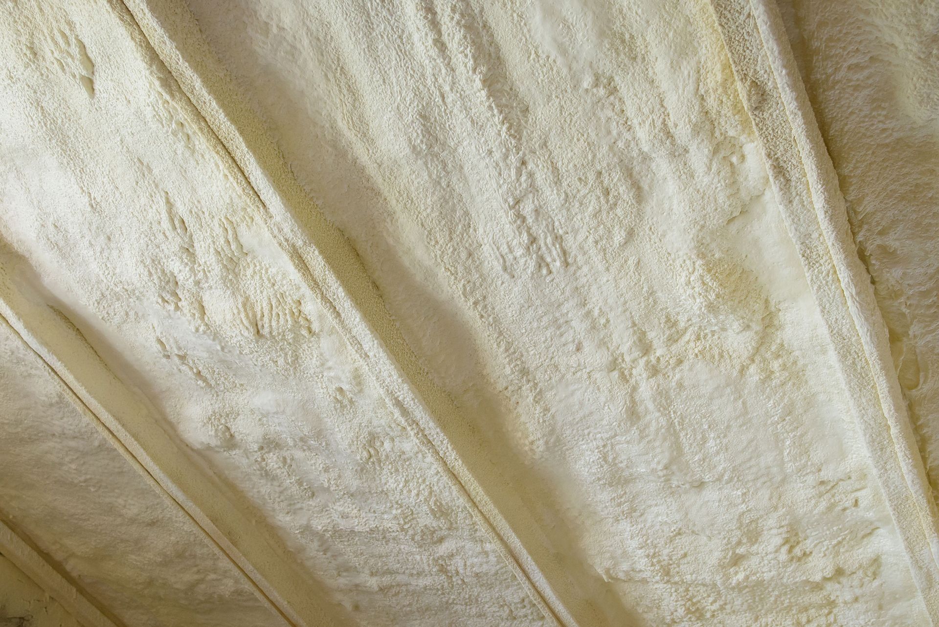 Close-up of beige insulated ceiling panels with visible seams and textured surface