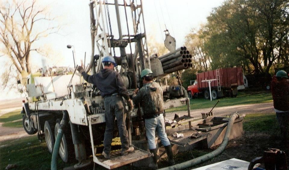 A group of men are working on a water well