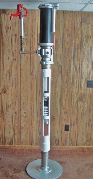 A model of a machine is sitting on a table in front of a wooden wall.