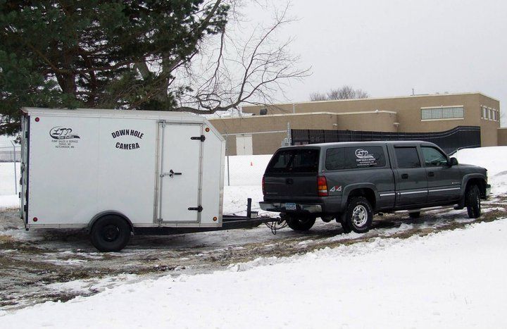 A truck is pulling a trailer in the snow