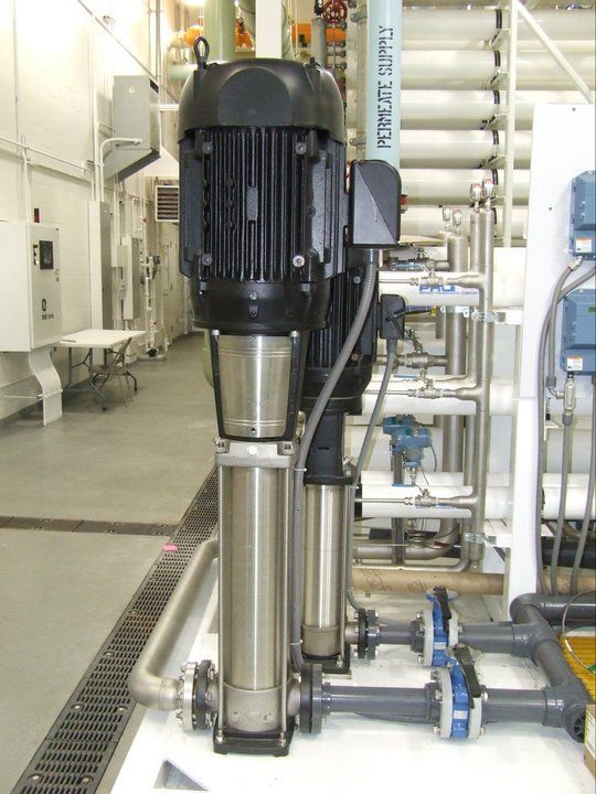 A stainless steel pump with a black motor in a room