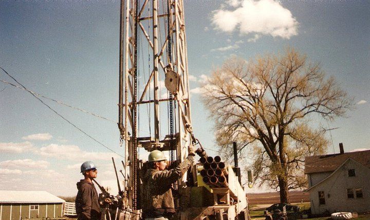 A group of men are working on a large machine in a field.