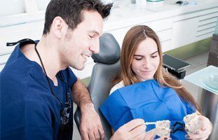 Dentist showing dentures to woman