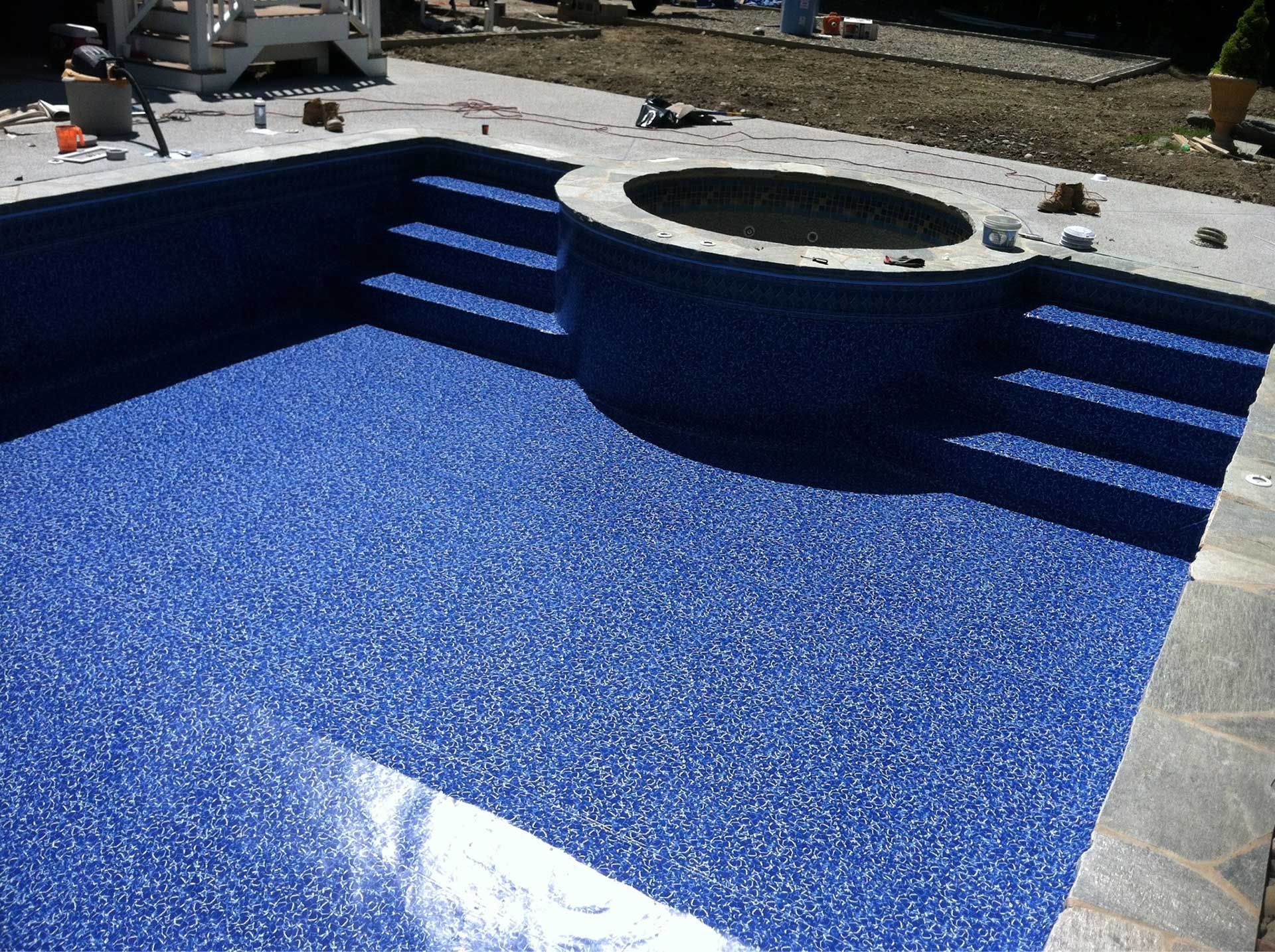 A swimming pool with blue tiles and stairs