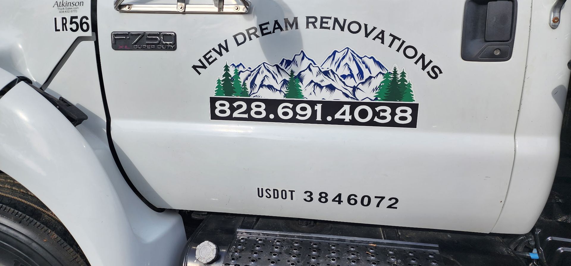 A white truck with the words `` new dream renovations '' written on the side of it.