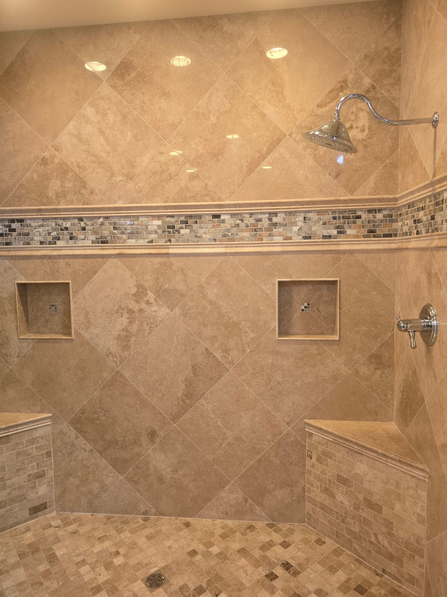 A bathroom with a walk in shower and a bench.
