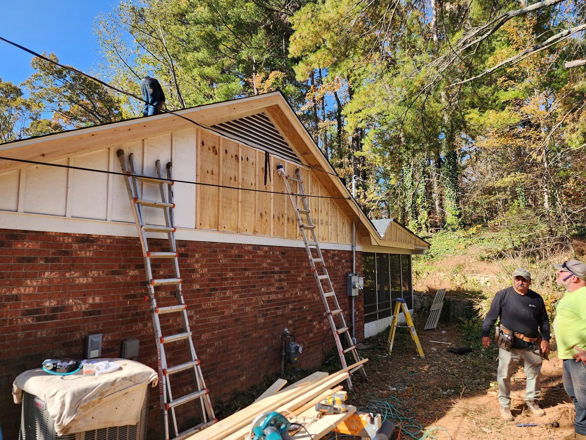 A man is working on the roof of a house.