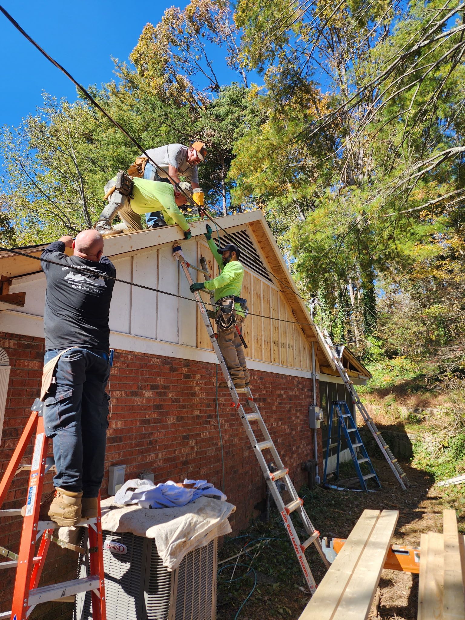A group of men are working on the roof of a house.