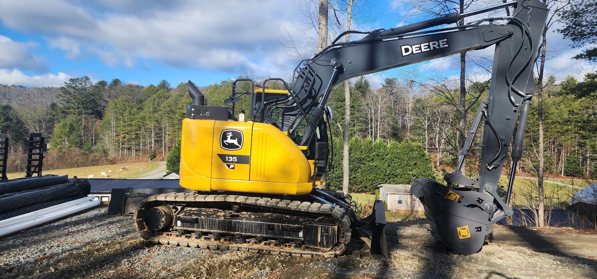 A yellow and black excavator is parked on the side of the road.
