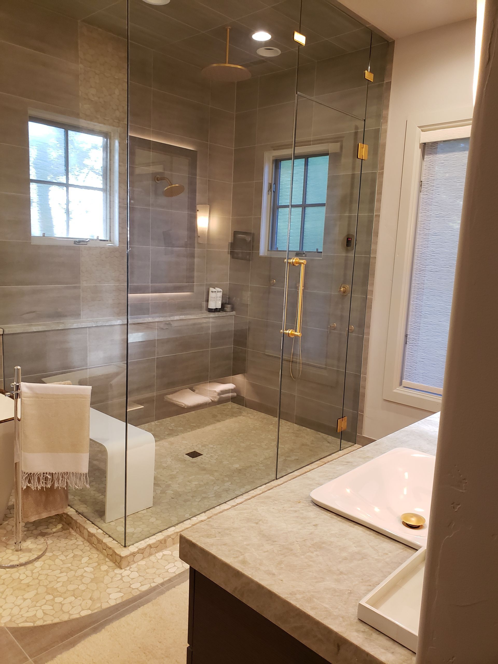 A bathroom with a walk-in shower and a sink