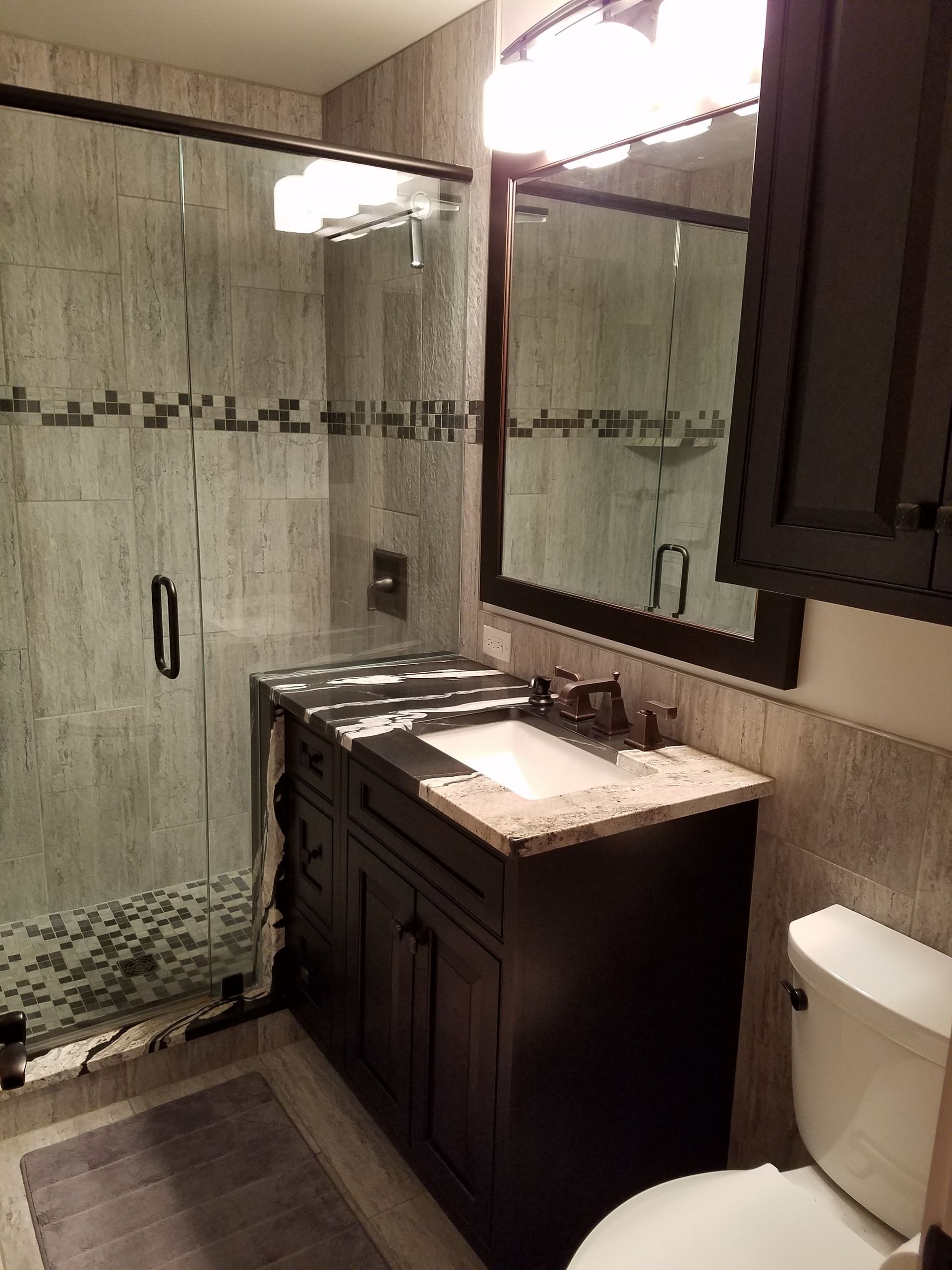 A bathroom with a sink, toilet, and shower